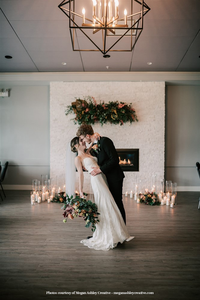 A-bride-and-groom-share-a-kiss-in-a-room-with-a-fireplace-Pitt-Meadows-Golf-Club